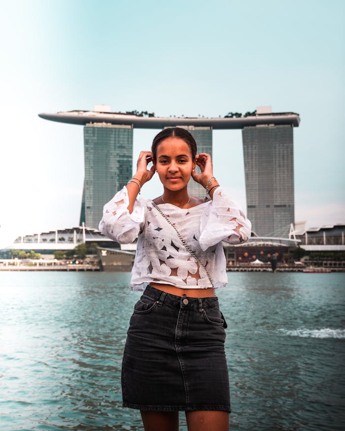 Woman posing in front of Marina Bay Sands in Singapore, exuding summer vibes.